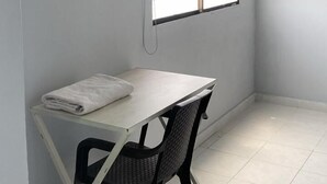 A small, functional room with a desk, chair, and air conditioning unit. - Hotel Tres Estrellas Fundacion (Fundación)