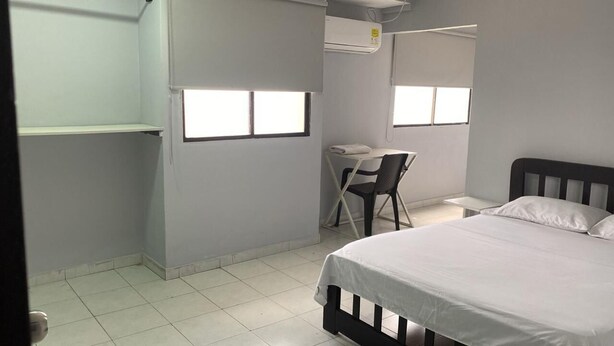 A bedroom with a bed, a desk, and two windows. - Hotel Tres Estrellas Fundacion (Fundación)