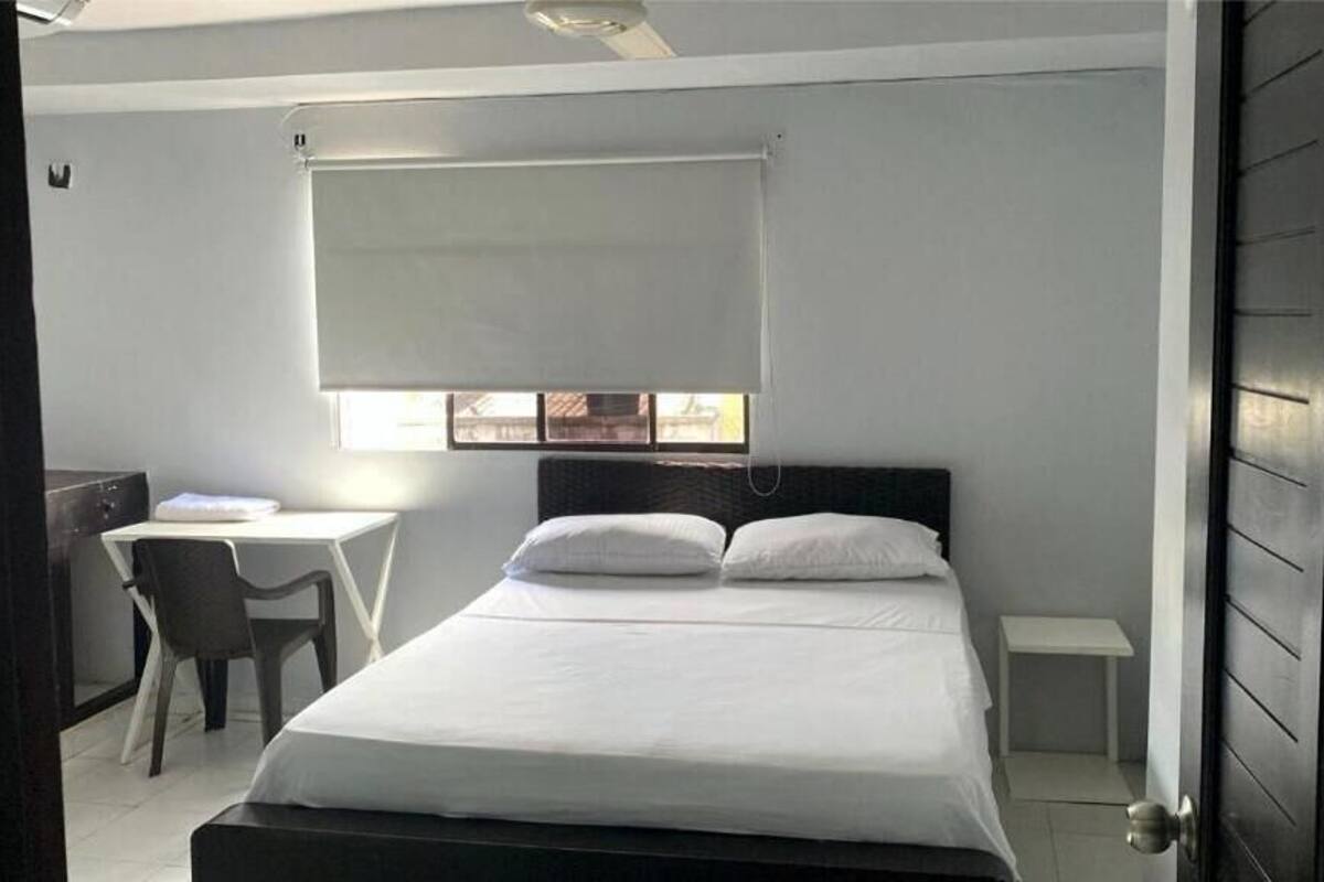 Una camera da letto con un letto, una scrivania e una sedia.