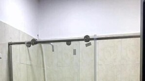 A small, enclosed shower area with a glass door, a toilet, and a sink. - Hotel Tres Estrellas Fundacion (Fundación)