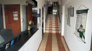 A hotel reception area with a reception desk, a chandelier, a staircase, and a sign indicating the reception is open. - Hotel El paraíso Funza  (Funza)