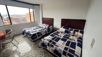 Habitación de hotel con dos camas, una silla y vista a la ciudad.