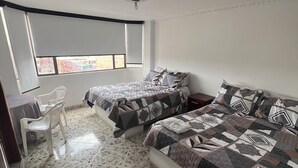 A bedroom with two beds, a desk, and a chair. - Hotel El paraíso Funza  (Funza)