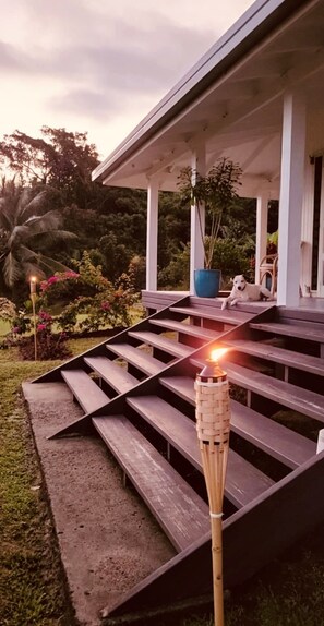 A wooden staircase leading to a covered porch with a torch. - Beachfront Retreat at Rainbow Reef (Savusavu)