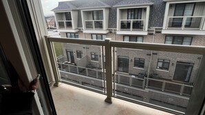 Uma varanda com vista para um prédio residencial com várias janelas e varandas.