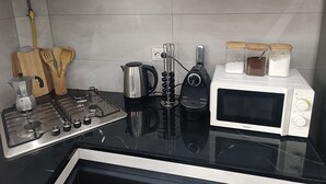 A kitchen with a gas stove, kettle, electric kettle, toaster, and microwave. - COMFORT in the heart of Algiers (Alger Centre)