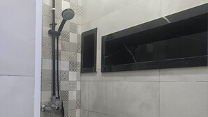 A shower with a black floor and a tiled wall. - COMFORT in the heart of Algiers (Alger Centre)