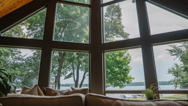 A room with large windows, a wooden ceiling, and a view of trees and water. - Lake Ida+Fish+Foosball+Bball+PingPong+Fire+Porch (Alexandria)