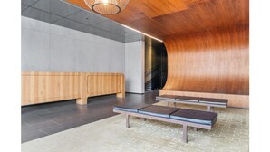 Un espace d’attente moderne avec des bancs en bois et un escalier.