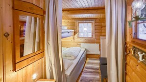 A wooden cabin interior with a bed, a window, and a radiator. - Beautiful home in Ljørdalen (Ljørdalen)