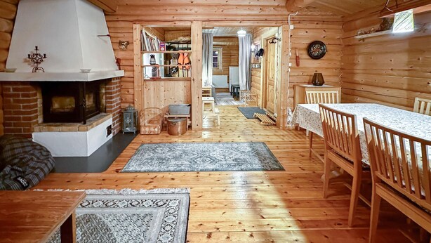 A cozy log cabin interior with a fireplace, wooden furniture, and a dining area. - Beautiful home in Ljørdalen (Ljørdalen)