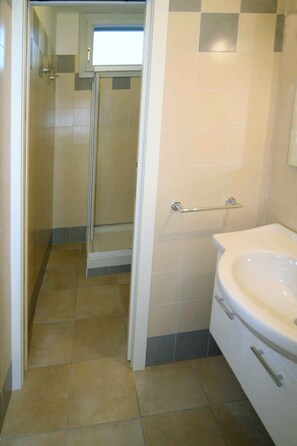 A bathroom with a shower, toilet, and sink. - Holiday apartment with air conditioning and balcony (Lignano Sabbiadoro)