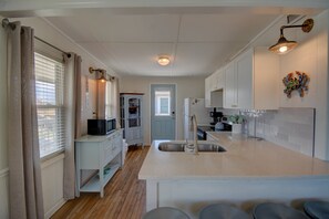 A kitchen with a central island, a sink, and a microwave. - Cozy 2BR retreat in North Topsail Beach, perfect for relaxing getaways (North Topsail Beach)