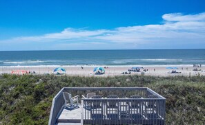 A beach with a wooden deck and chairs, overlooking the ocean. - Cozy 2BR retreat in North Topsail Beach, perfect for relaxing getaways (North Topsail Beach)