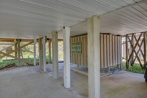 A covered outdoor area with wooden beams and a concrete floor, featuring a sign with a message. - Cozy 2BR retreat in North Topsail Beach, perfect for relaxing getaways (North Topsail Beach)