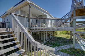 Eine Holzterrasse mit einer Treppe, die zu einem überdachten Veranda-Bereich führt.