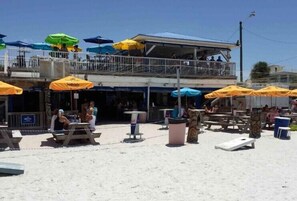 Ein Restaurant direkt am Strand mit Außenbereich und Sonnenschirmen.