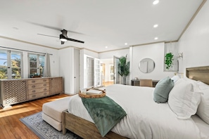 A bedroom with a large bed, a ceiling fan, a dresser, and a view of the outdoors. - Prestigious Hills Estate | Stunning Pool & Hot Tub Views (San Diego)