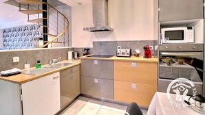 Een moderne keuken met een ingebouwde magnetron, broodrooster en oven.