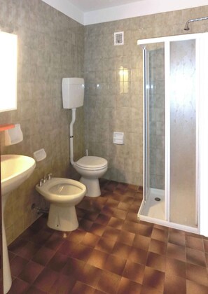 A bathroom with a sink, bidet, toilet, and a glass-enclosed shower. - Holiday apartment mit Klimaanlage und Balkon (Lignano Sabbiadoro)