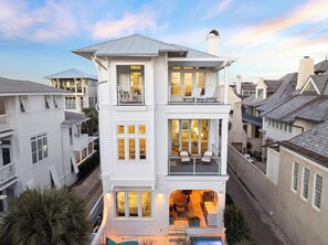 Ein mehrstöckiges Haus mit Balkon, großen Fenstern und einem gut beleuchteten Innenraum.