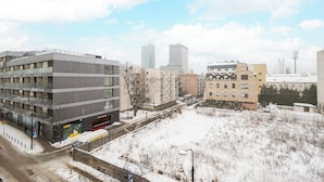 Um edifício moderno com vários andares, área de estacionamento e paisagem coberta de neve.