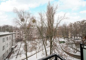 Un patio cubierto de nieve, con árboles desnudos y un edificio al fondo.