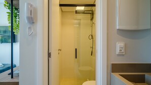 Ein modernes Badezimmer mit einer Duschkabine, einer Toilette und einem Waschbecken mit Arbeitsplatte.