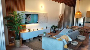 En moderne stue med sofa, tv og planter.