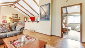 A spacious living room with a wooden ceiling, a fireplace, a sofa, and a coffee table. - 3BR with Epic Mountain Views and Huge Deck! (Estes Park)