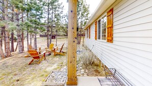 Eine Holzterrasse mit Adirondack-Stühlen und einem Betonpflanzgefäß.