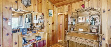 A wooden interior with a fireplace, bookshelves, and a mounted animal head.