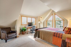 A bedroom with a bed, a desk, a chair, and a television. - 3BR Three-story home with epic mountain views & fireplace (Estes Park)
