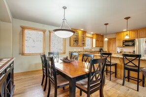 A spacious kitchen with wooden cabinets, a central island, and pendant lighting. - 3BR Three-story home with epic mountain views & fireplace (Estes Park)