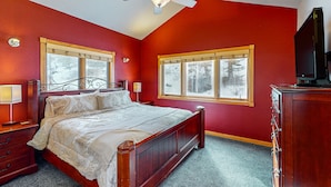 A bedroom with a wooden bed, two bedside tables, a ceiling fan, and two windows with blinds. - Two BR condo w/ Brand NEW HOT TUB and great views! Community pool perfect for kids (Estes Park)