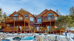 A wooden cabin with multiple balconies and a stone foundation. - Two BR condo w/ Brand NEW HOT TUB and great views! Community pool perfect for kids (Estes Park)