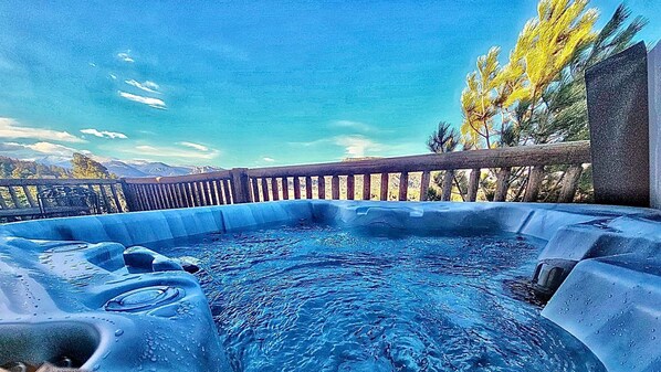 A hot tub with a wooden deck and a mountainous backdrop. - Two BR condo w/ Brand NEW HOT TUB and great views! Community pool perfect for kids (Estes Park)
