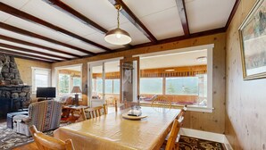 Un vaste espace dédié à la salle à manger, avec une grande table en bois, des chaises et une cheminée en pierre.