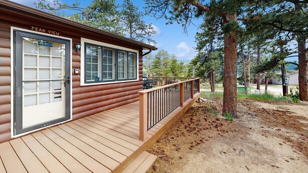 A log cabin with a deck and a sign that reads "PEAK VIEW". - Ideal vacation home with wraparound deck & Rocky Mountain view (Estes Park)