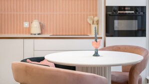 Una cocina moderna con una mesa de comedor redonda y dos sillas rosas.