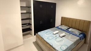 Une chambre comprenant un lit, une armoire et une étagère intégrée.