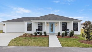 A single-story house with a white exterior, a blue front door, and a garage.