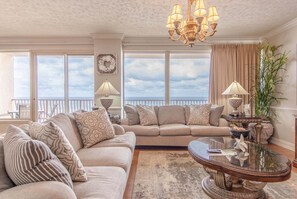 A living room with a sofa, a coffee table, and a chandelier. - Hidden Luxury 703-Gulf-Front Luxury-Sleeps 10 (Panama City)