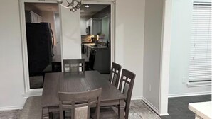 A dining area with a dark wooden table and chairs, a chandelier, and a view into the kitchen. - Luxurious, peaceful, & fun 4-bedroom house with a game room in charming La Porte (La Porte)