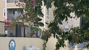 A pool area with lounge chairs, a sign for the Riverfront Condominium Association, and a building in the background. - Downtown Nashville Condo • 1 Mile to Broadway • Pool & Parking (Nashville)