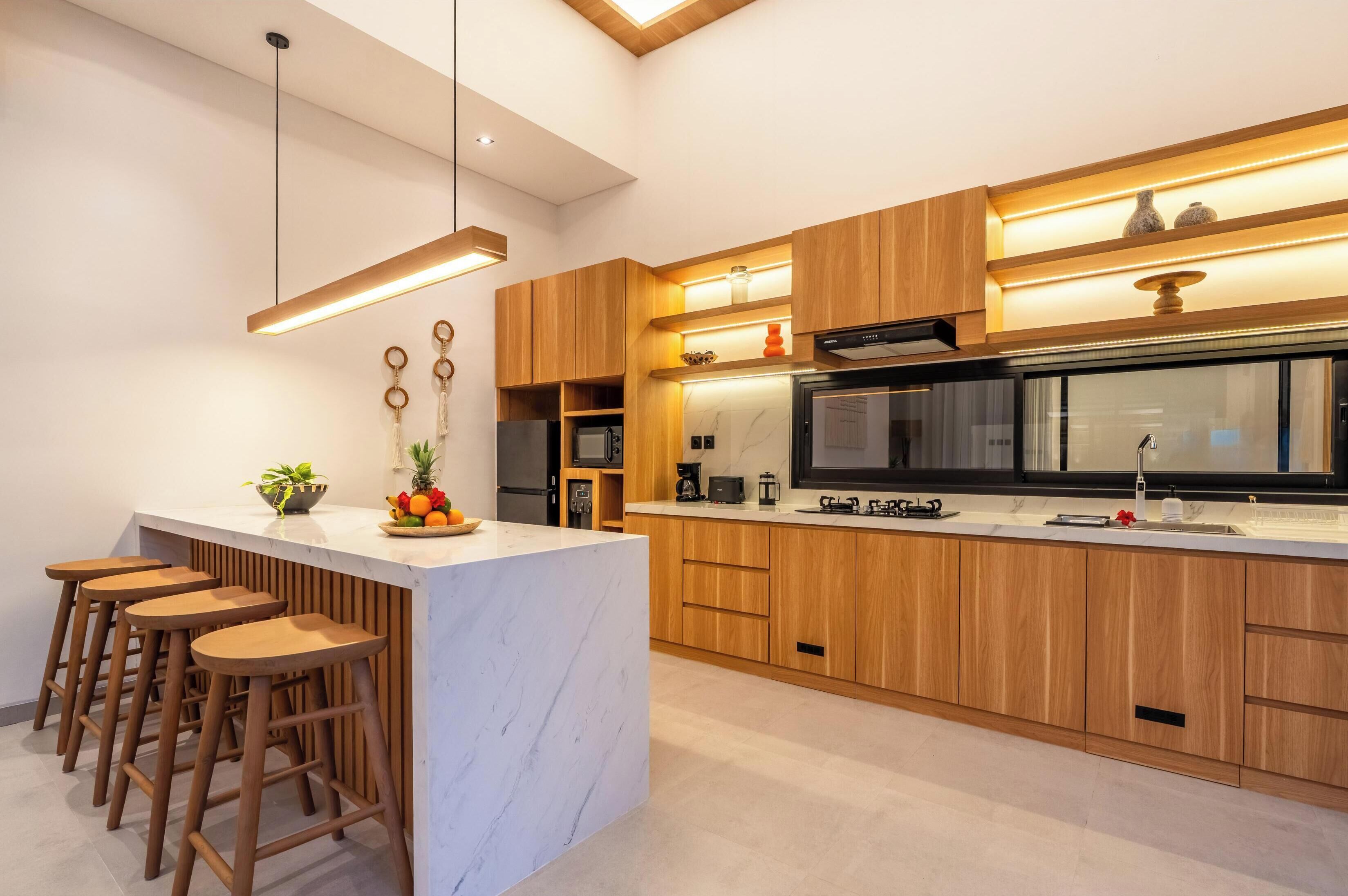 Une cuisine moderne dotée d’un îlot central, de meubles en bois et de tabourets de bar.