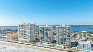 Ein Küstenhotel mit mehreren Hochhäusern, einem Strand und einem Yachthafen.