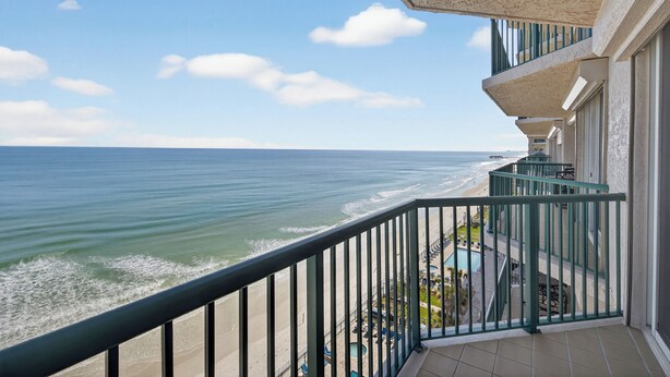 Ein Balkon mit Blick auf das Meer und den Strand.