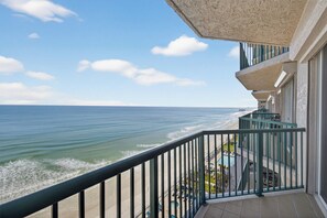 Een balkon met uitzicht op zee en strand.