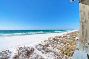A beach view with a wooden structure, sandy beach, and dunes. - Gulf Front- Directly On The Beach- Sunchase 2A (Miramar Beach)